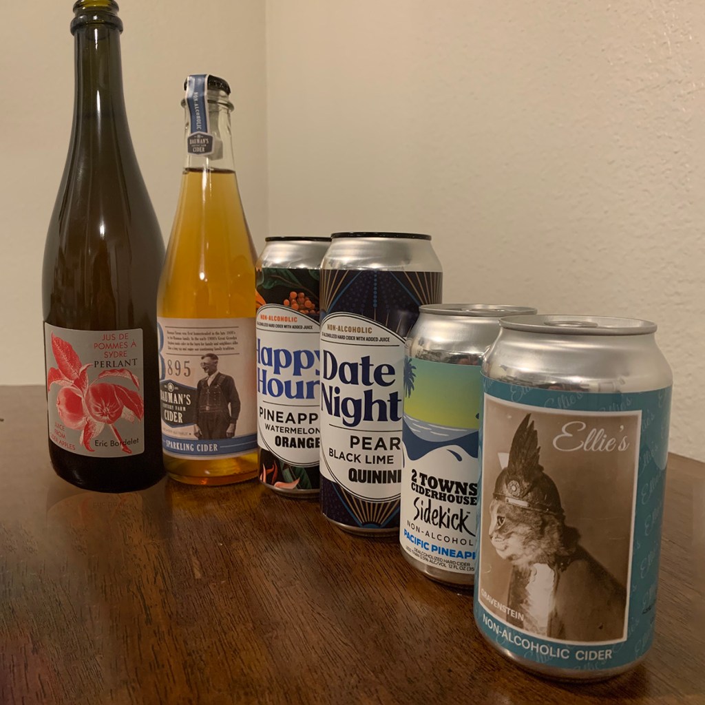 A series of non-alcoholic ciders sits atop a wooden table