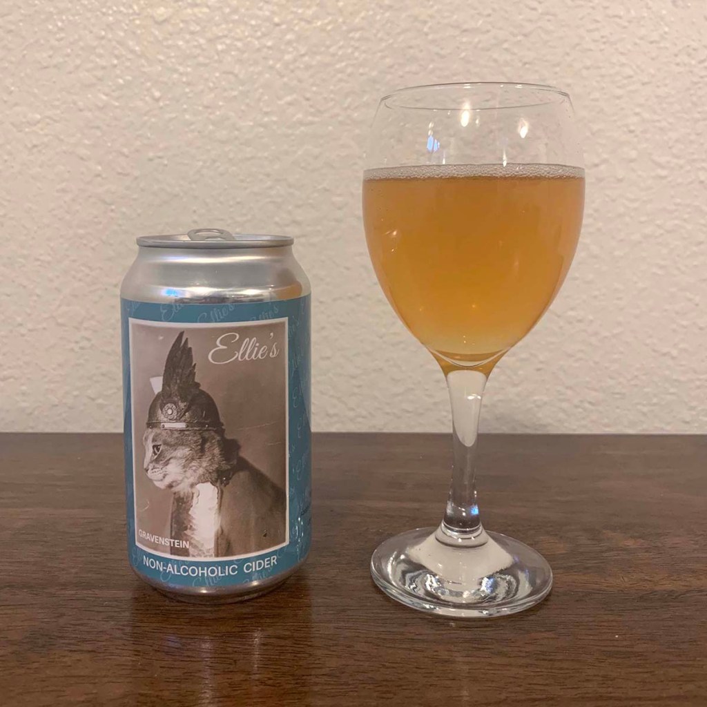 A glass of cider sits next to a can of Ellie's Non-Alcoholic Gravenstein cider from Tilted Shed